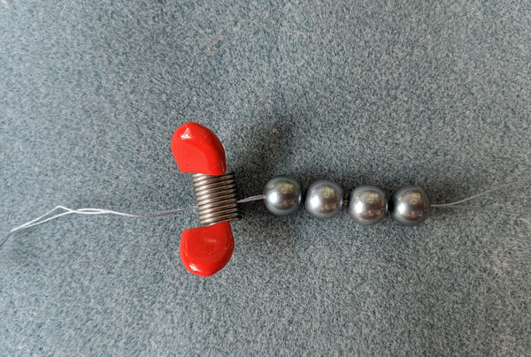 Step 7: Tail secured to prevent pearls from slipping off.