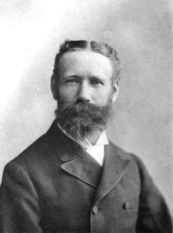 Black and white portrait of a Victorian gentleman with cultured pearls in his formal suit.