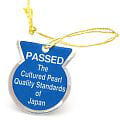 Blue and gold medal-style ornament with PASSED text, symbolizing pearl quality in purchasing pearls.