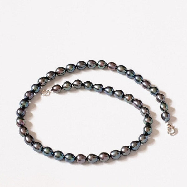 Dark gray pearl necklace with silver clasps featuring black freshwater pearls.