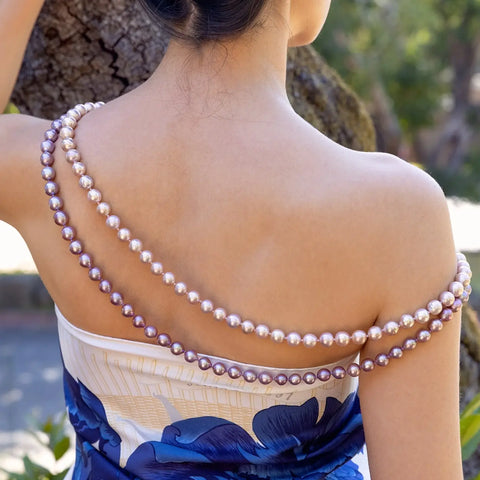 Elegant pearl necklace on bare shoulders with navy blue dress showcasing essential pearl care.