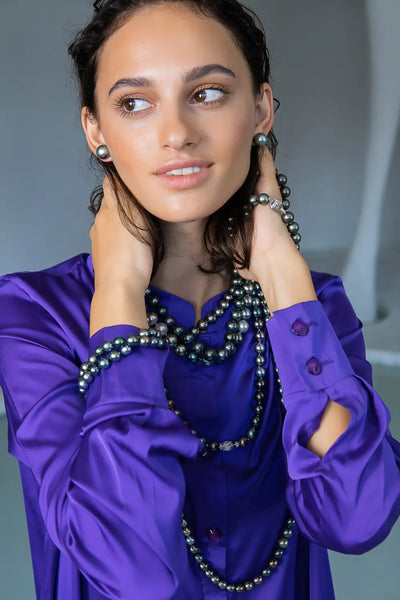 Long dark green beaded necklace worn with purple blouse, tips to wear pearls stylishly.