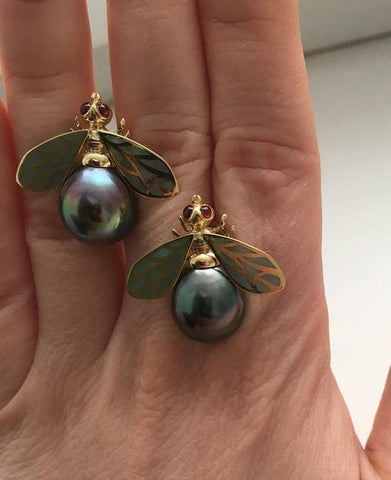 Pearl and gold bee-shaped earrings with green enamel wings featuring Tahitian pearls.