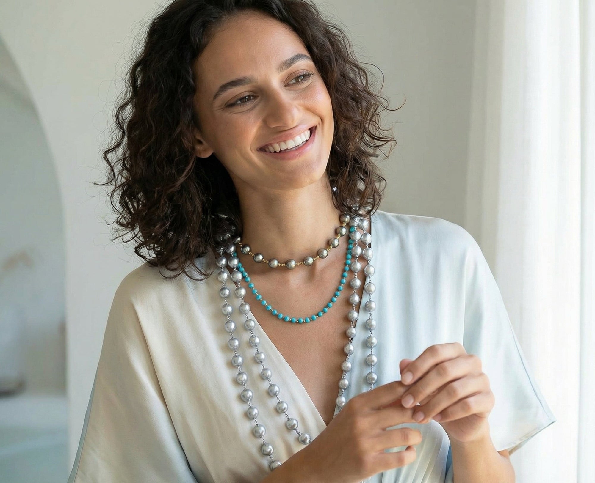 Woman wearing a long necklace with a blurred indoor background