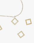 a gold necklace with square and rectangle pendants