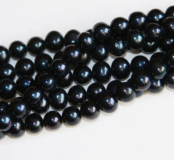 Strand of glossy black pearls including Tahitian and black freshwater varieties.