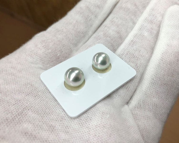 Two pearl stud earrings displayed on a card featuring Blue Akoya Pearls.