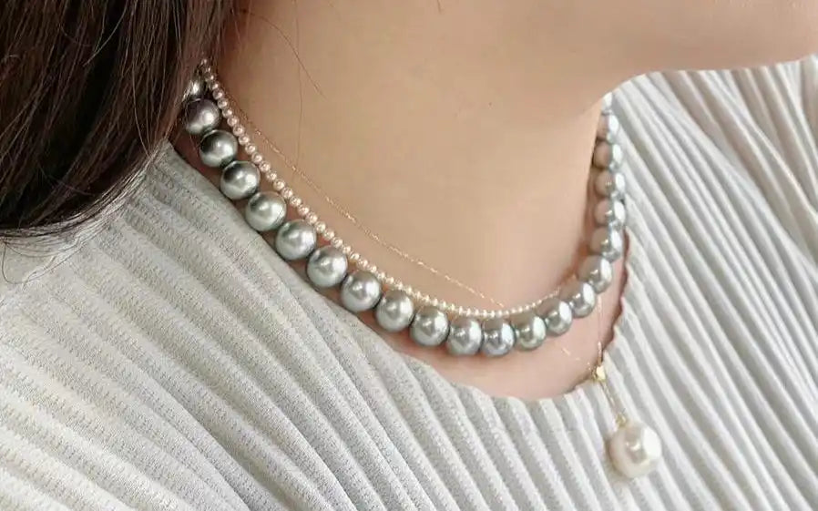 A woman wearing layered pearl necklaces.